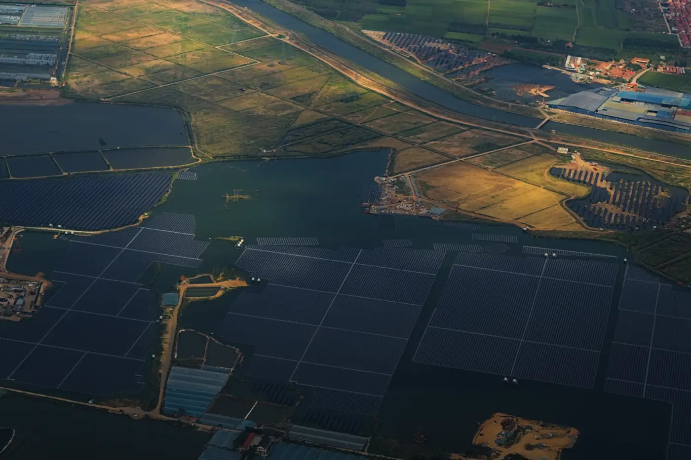 Aerial view of large solar panel arrays at golden hour